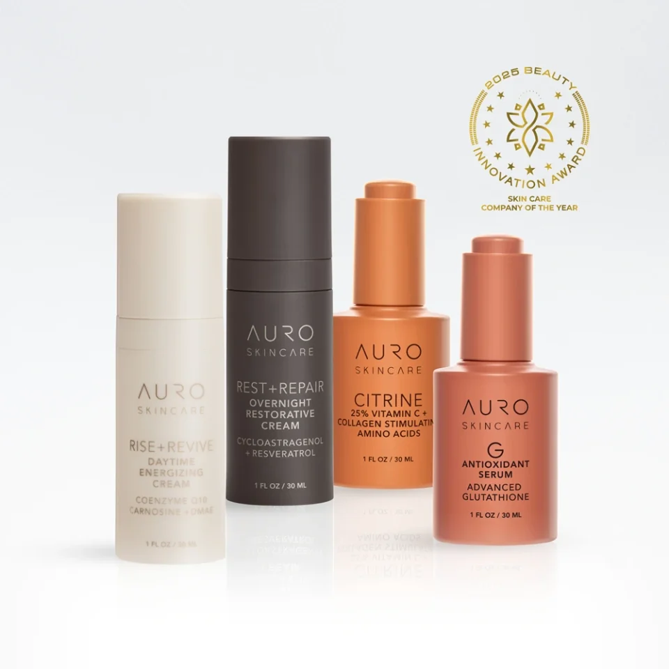 Four AURO Skincare products—Rise+Revive, Rest+Repair, Citrine, and Antioxidant Serum—are displayed upright with a gold award emblem in the background.